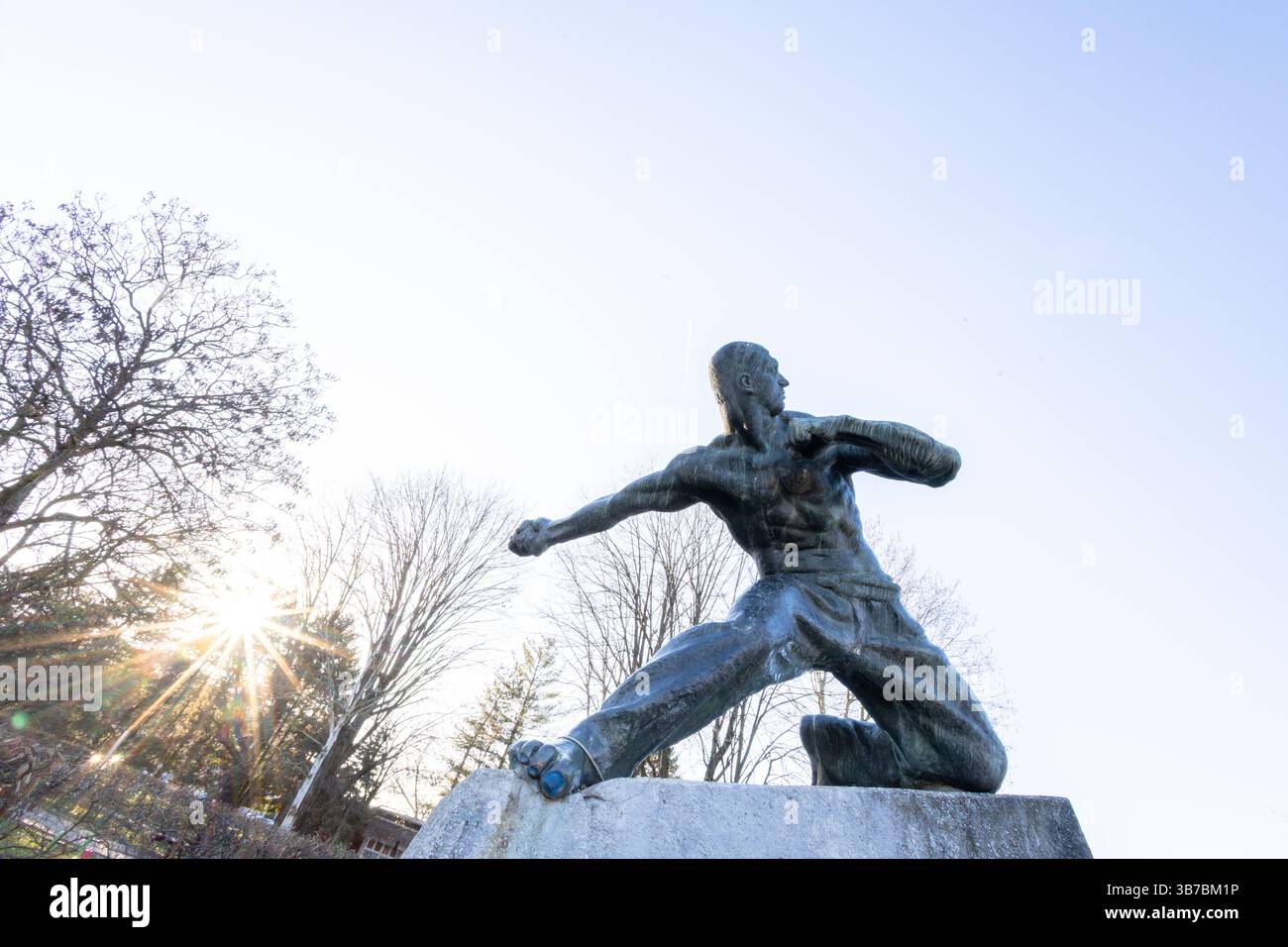NOVA GORICA, CROAZIA, 03.19.2020: Una fotografia drammatica di una statua di guerriero in un parco, vista contro un cielo soleggiato e limpido che si illumina. L'immagine evoca Foto Stock