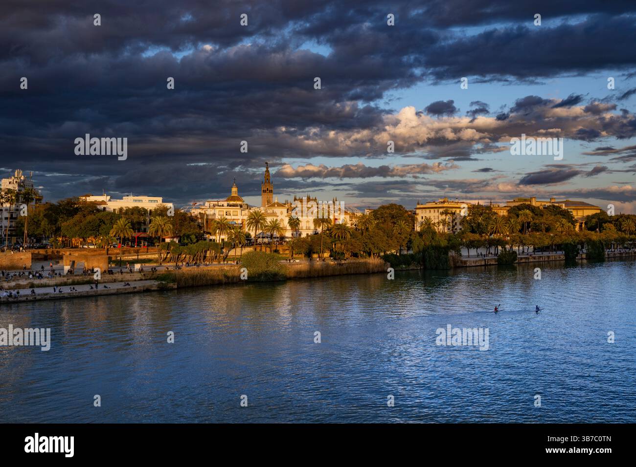 Vista sul fiume Guadalquivir al tramonto. Sullo sfondo si trova la torre della Giralda e la cattedrale di Siviglia. Andalusia, Spagna Foto Stock