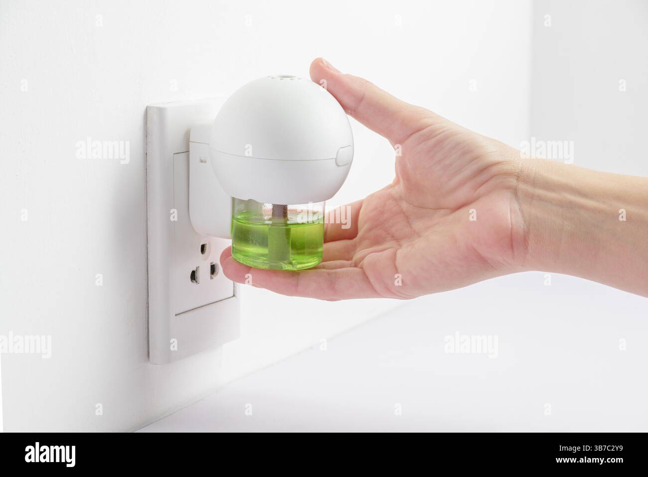 Dispositivo elettrico per inserimento manuale femminile con repellente per zanzare Foto Stock