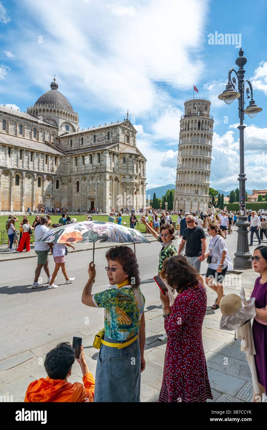 Pisa, Italia - 12.6,2024: I turisti che posano di fronte alla Torre pendente di Pisa (Torre pendente di Pisa), usando la prospettiva forzata per apparire come se fossero in attesa Foto Stock
