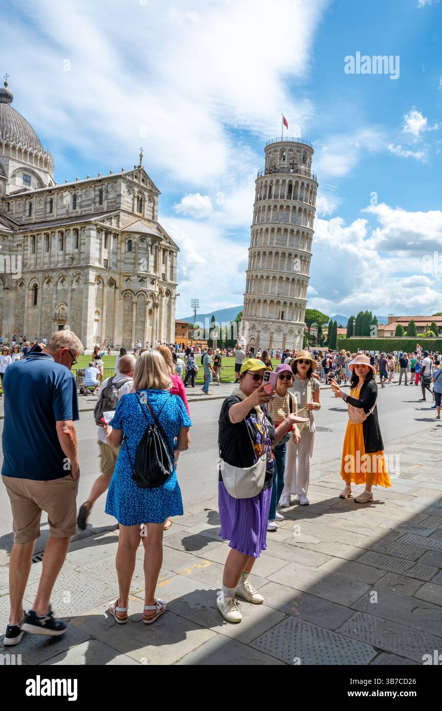 Pisa, Italia - 12.6,2024: I turisti che posano di fronte alla Torre pendente di Pisa (Torre pendente di Pisa), usando la prospettiva forzata per apparire come se fossero in attesa Foto Stock
