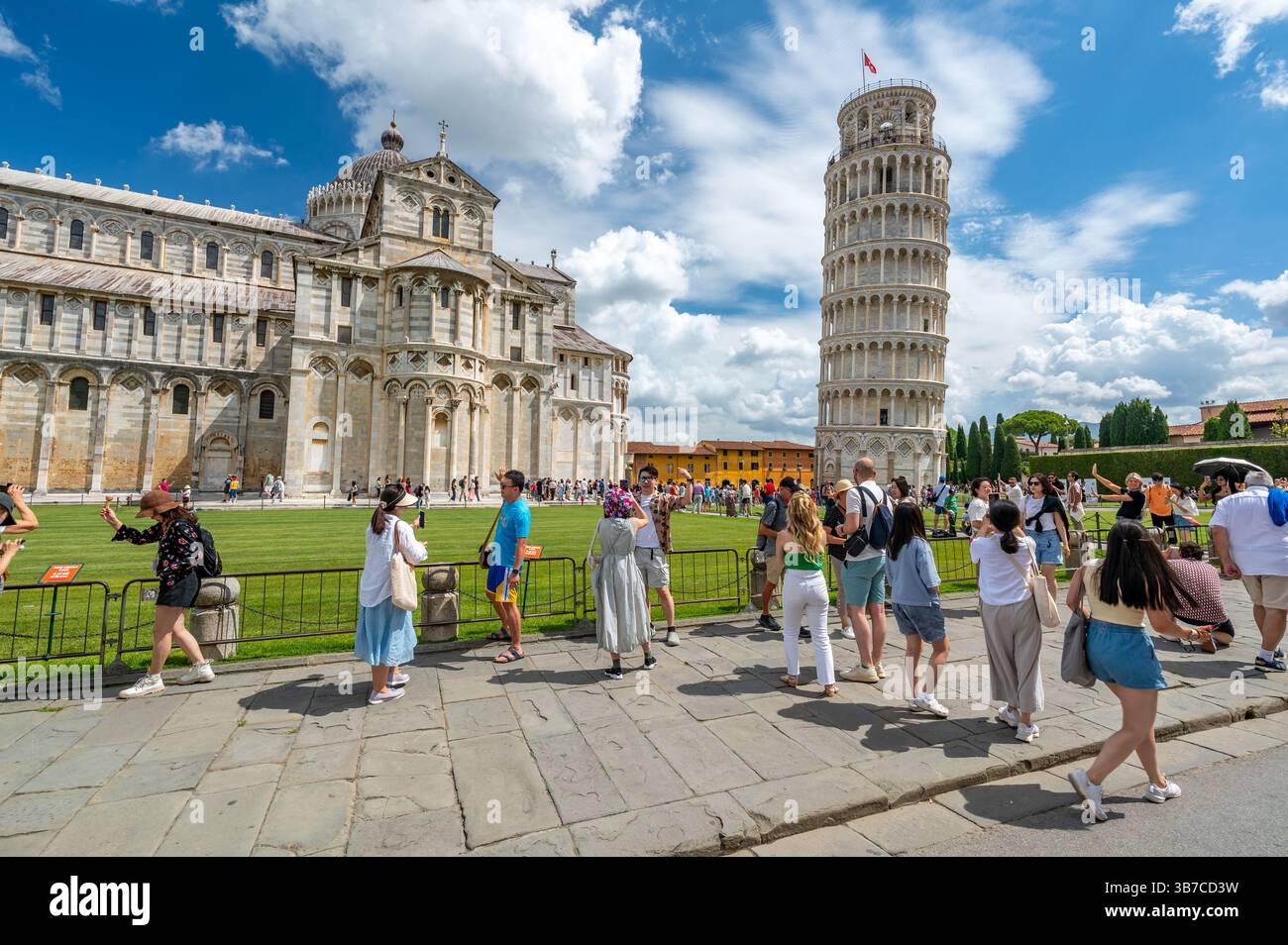 Pisa, Italia - 12.6,2024: I turisti che posano di fronte alla Torre pendente di Pisa (Torre pendente di Pisa), usando la prospettiva forzata per apparire come se fossero in attesa Foto Stock