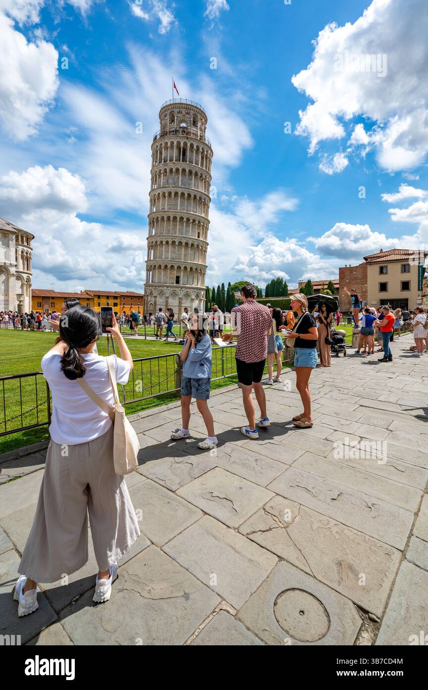 Pisa, Italia - 12.6,2024: I turisti che posano di fronte alla Torre pendente di Pisa (Torre pendente di Pisa), usando la prospettiva forzata per apparire come se fossero in attesa Foto Stock