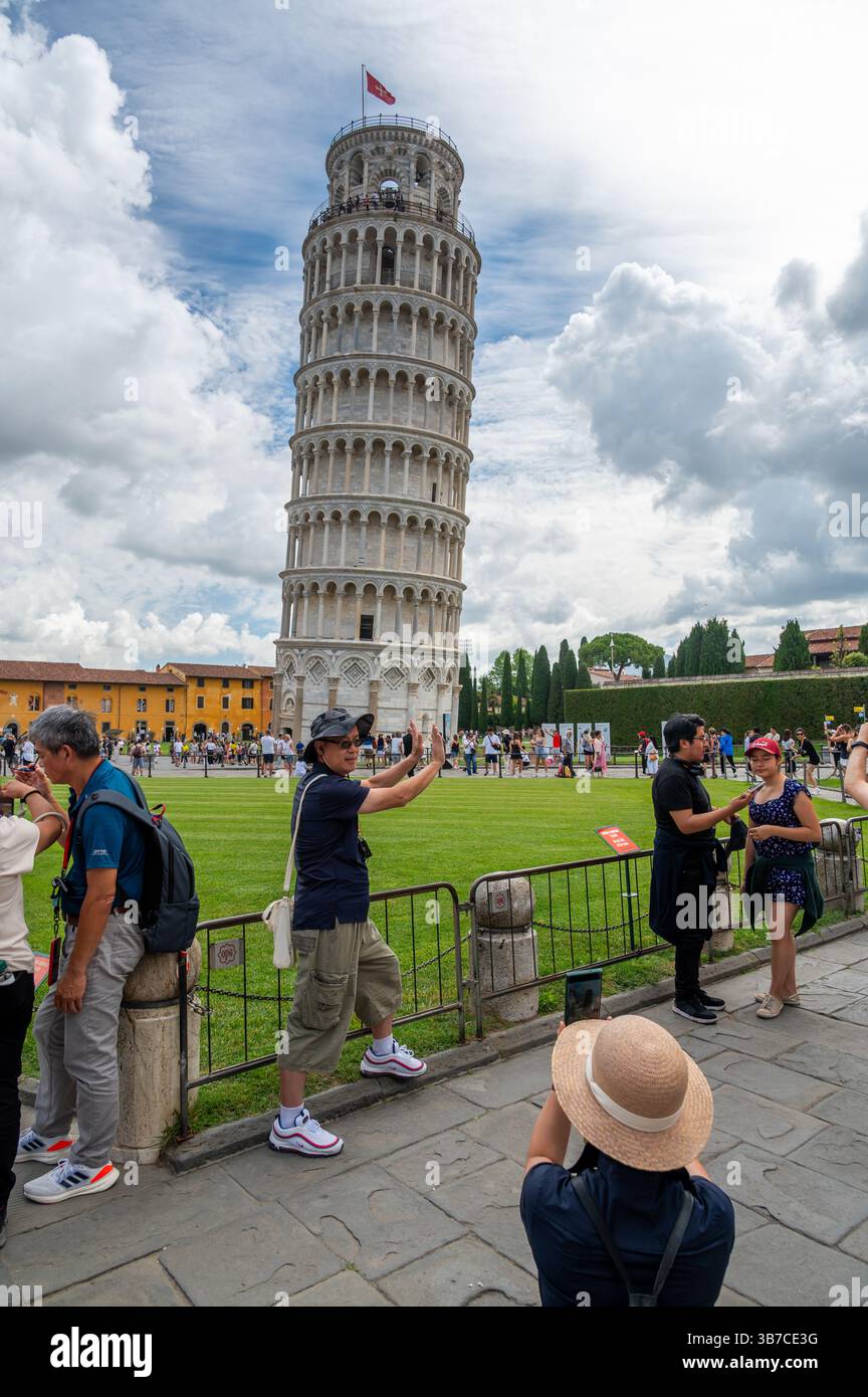 Pisa, Italia - 12.6,2024: I turisti che posano di fronte alla Torre pendente di Pisa (Torre pendente di Pisa), usando la prospettiva forzata per apparire come se fossero in attesa Foto Stock