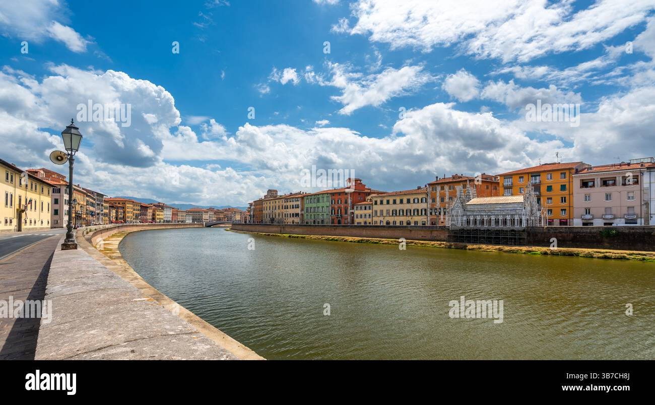 Centro città di Pisa, Italia, con il fiume Arno che scorre attraverso. Colorati edifici lungo il fiume fiancheggiano le rive sotto i luminosi cieli estivi in un caldo Medit Foto Stock