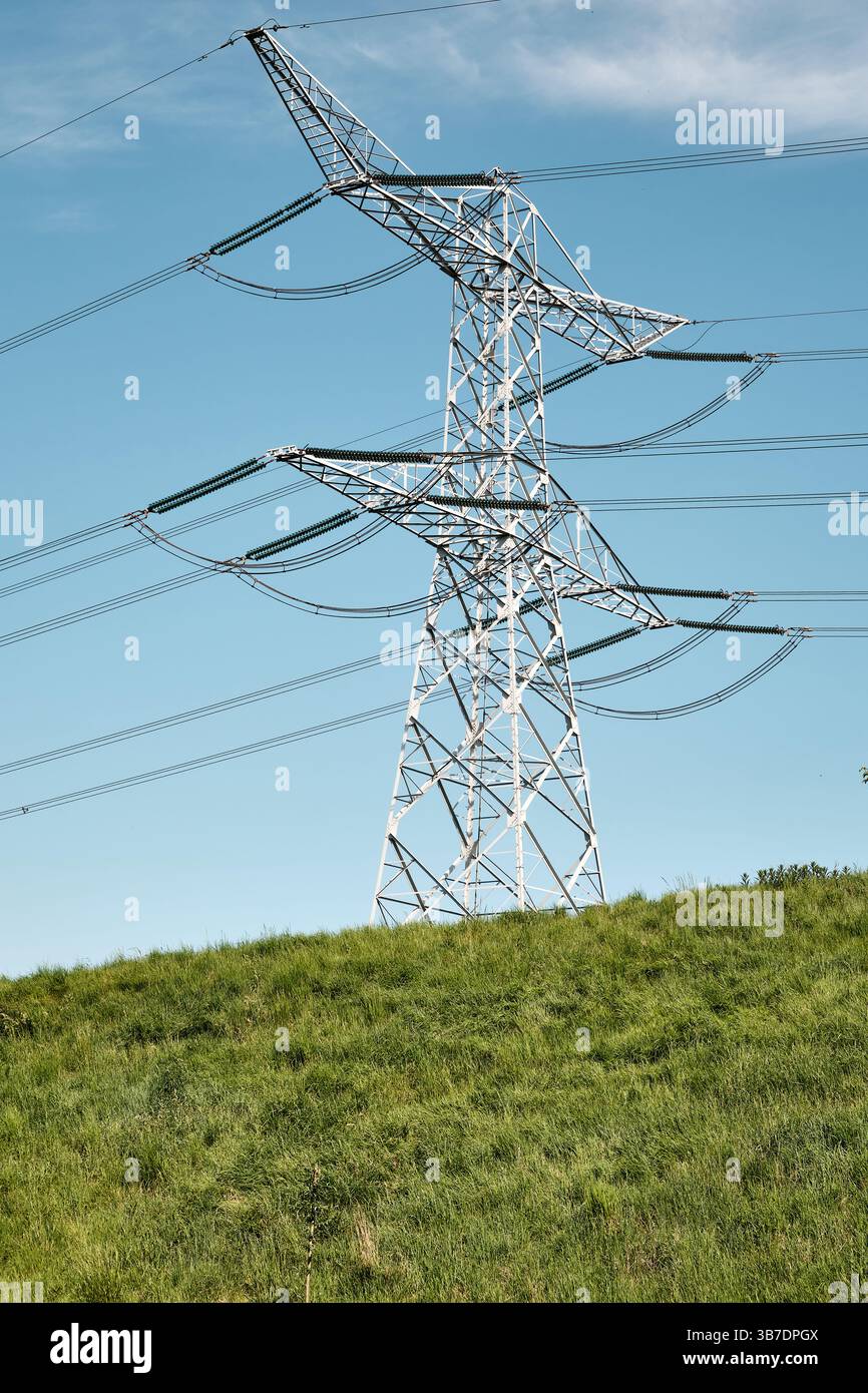 3 maggio 2025 - Kruiningen-Paesi Bassi: Paesaggio energetico rurale in Zelanda con torre Powerline da 150 kV e una vecchia diga ripida vicino a Kruiningen. Foto Stock