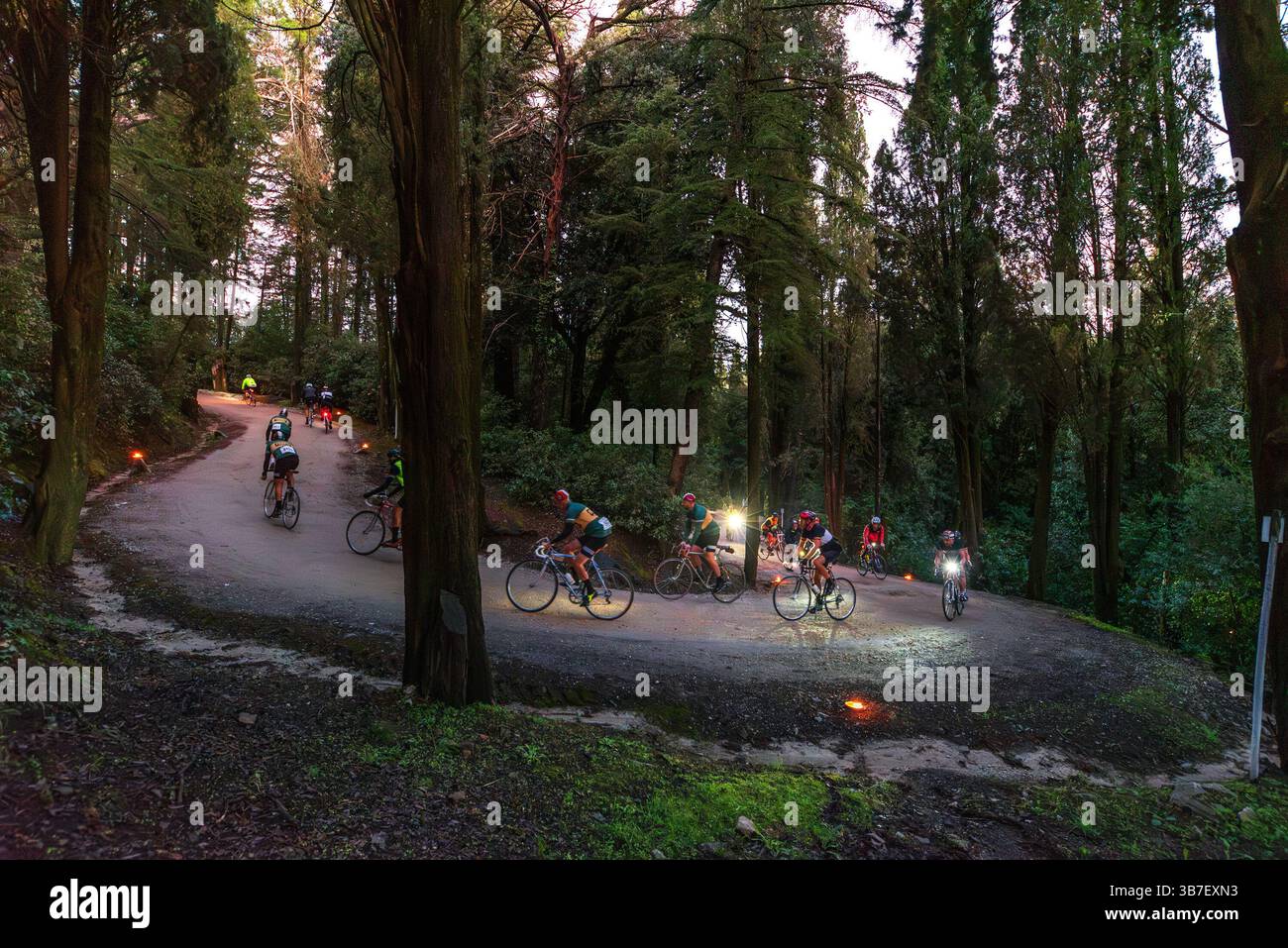 Ciclisti della corsa ciclistica Eroica di fronte ad un tornante lungo la strada che porta al castello di Brolio Foto Stock