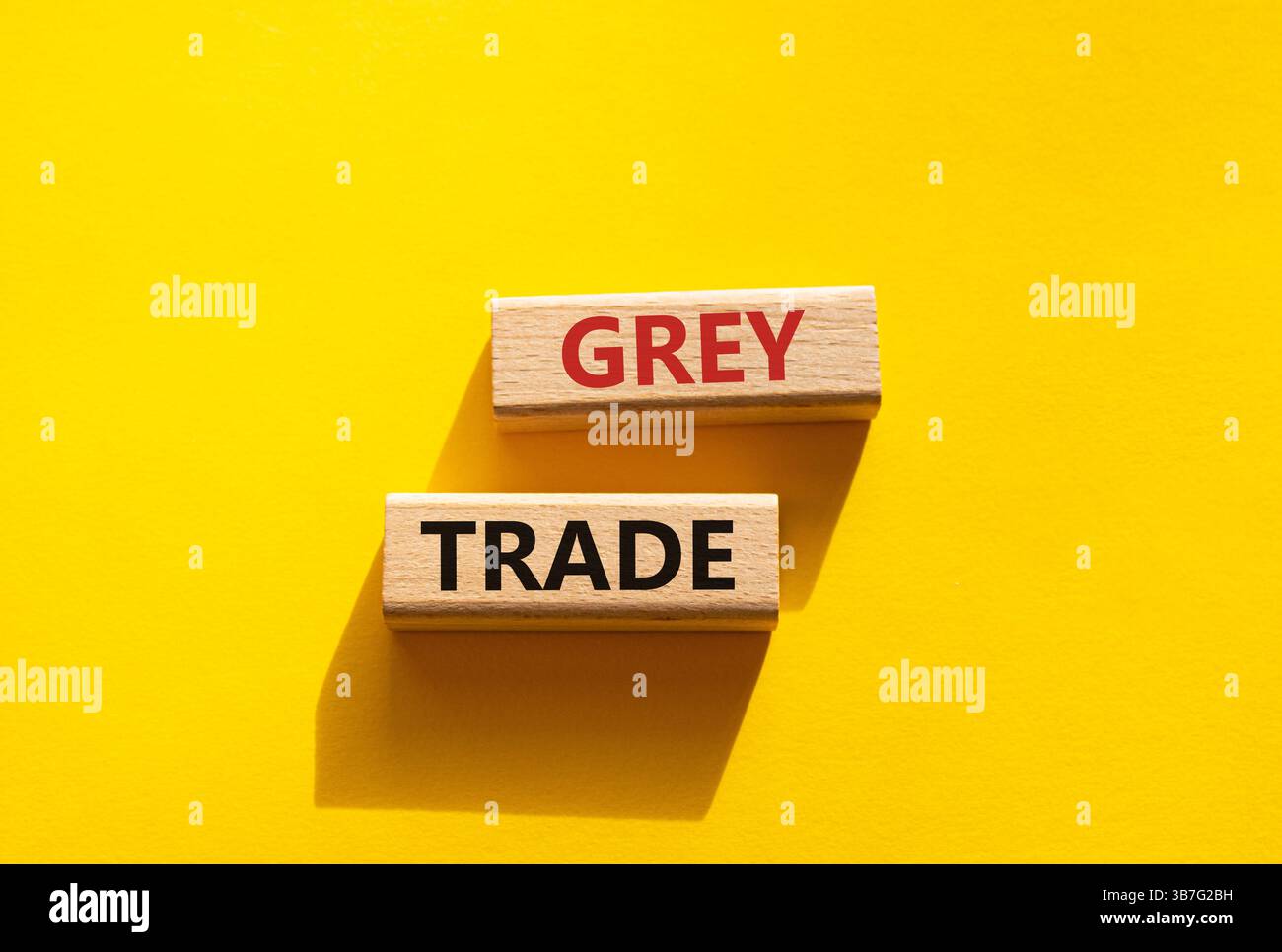 Simbolo commerciale grigio. Blocchi di legno con parole "commercio grigio". Bellissimo sfondo giallo. Business e concetto di commercio grigio. Copia spazio. Foto Stock