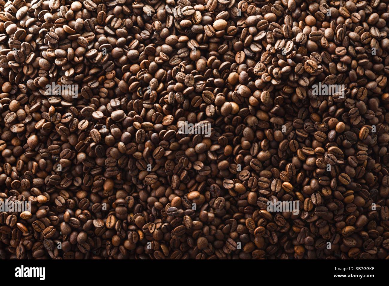 Dettagli sullo sfondo con una pila di chicchi di caffè tostati. Vista dall'alto. Foto Stock