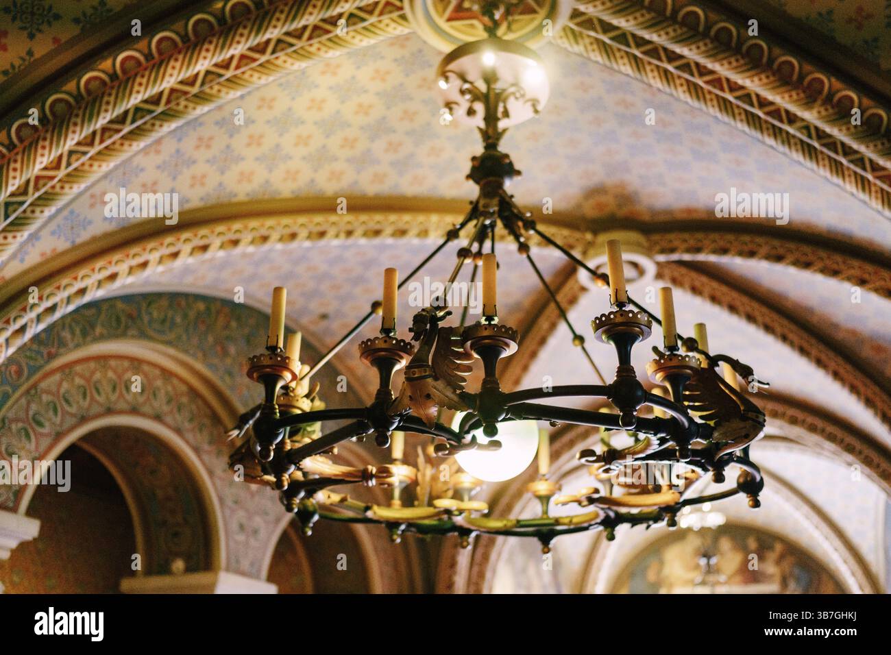 Lampadario medievale con candele di cera. Lampadario in metallo in stile castello con vere candele. Foto Stock