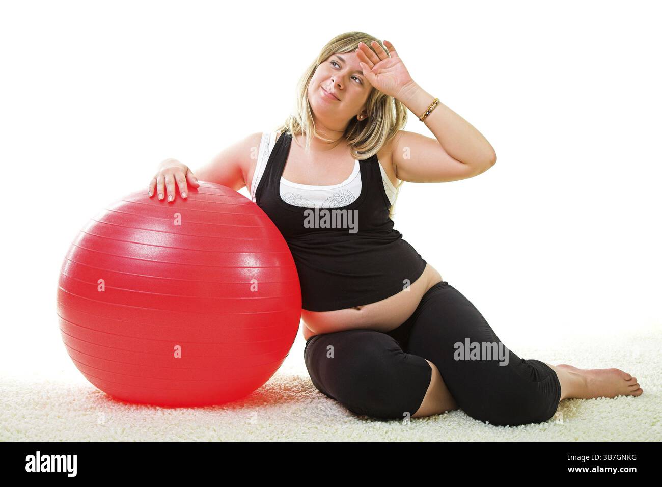Donna incinta che fa sforzo con la palla da ginnastica Foto Stock