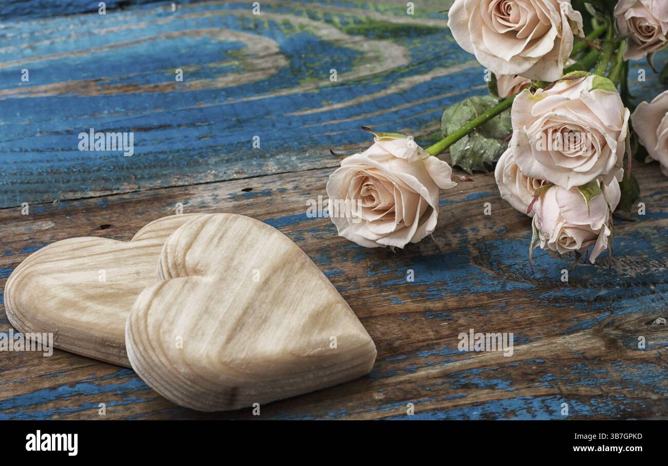 Due cuori di legno e bouquet di rose fresche Foto Stock