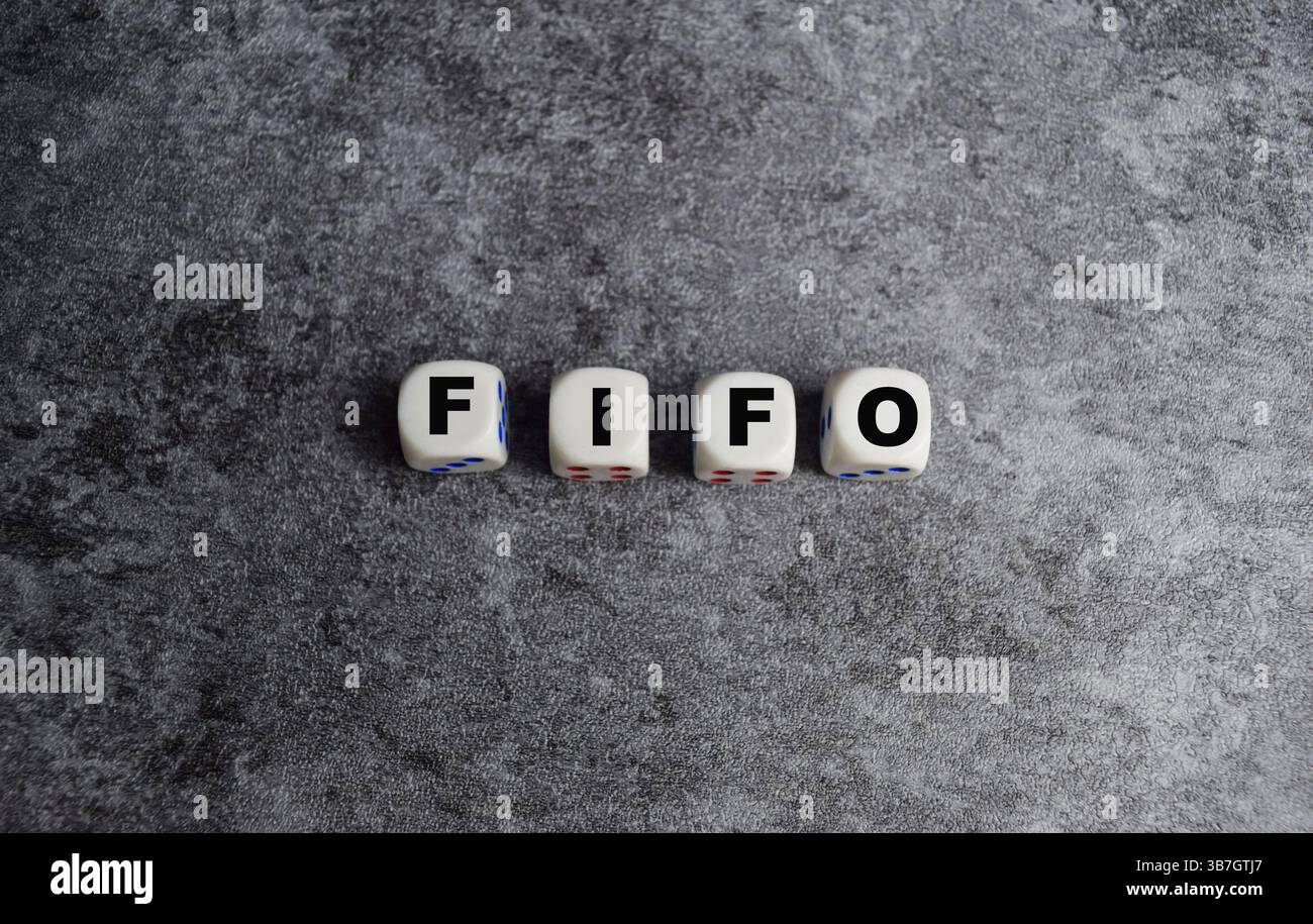 L'abbreviazione di uomo d'affari FIFO - primo in primo luogo fuori su blocchi di legno o dadi Foto Stock