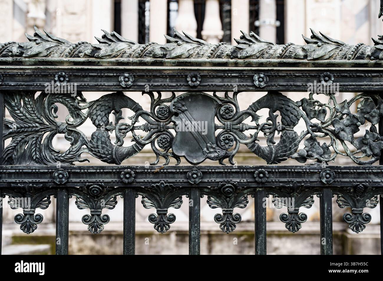 Antica recinzione in ferro battuto vicino al Duomo di Milano con spikelets, scudi, fiori e ricci. Foto Stock