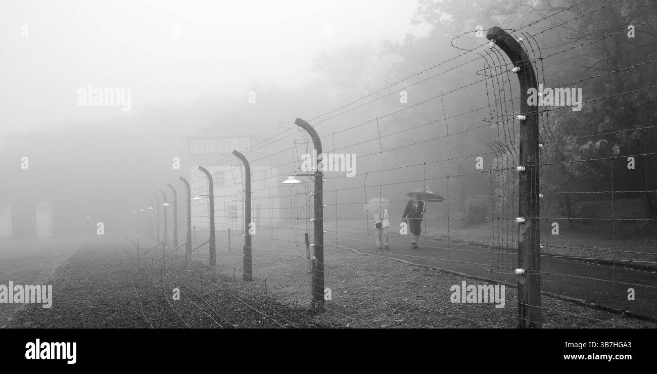 Recinto del campo ricostruito con persone nella nebbia al campo di concentramento della foresta di faggi, ora un memoriale del campo di concentramento, Weimar, Turingia, Germania, EUR Foto Stock