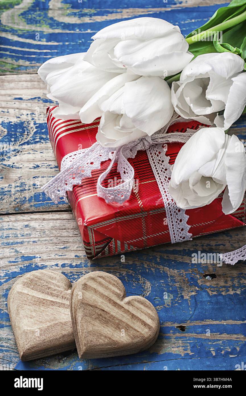 Simbolico cuore in legno sullo sfondo di bouquet di rose bianche Foto Stock