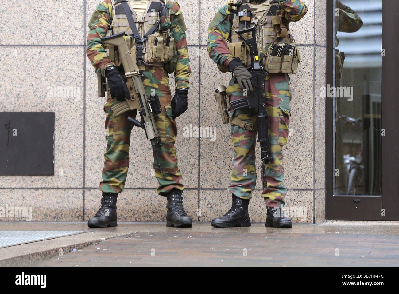 I soldati belgi sorvegliano le istituzioni europee. Persone irriconoscibili in uniforme. Misure di sicurezza dopo gli attentati a Bruxelles del 2016. Solo gambe Foto Stock