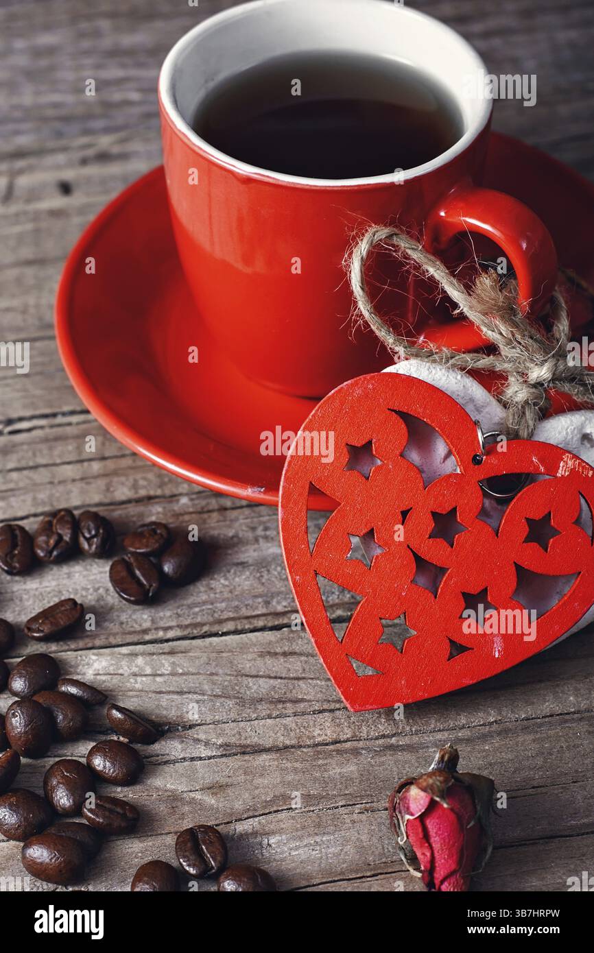 Tazza da caffè rossa decorata con cuori e cereali collegati Foto Stock