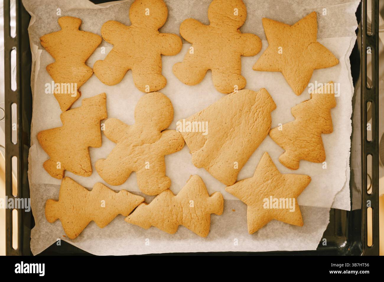 Pan di zenzero appena cotto su una teglia del forno, primo piano di varie forme di biscotti. Foto Stock