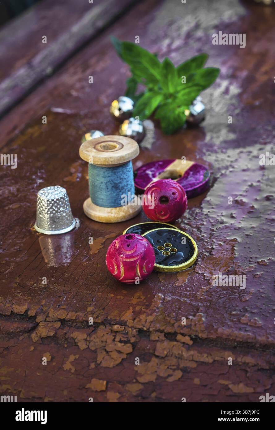 Set di filettature e bottoni su vecchio sfondo in legno Foto Stock
