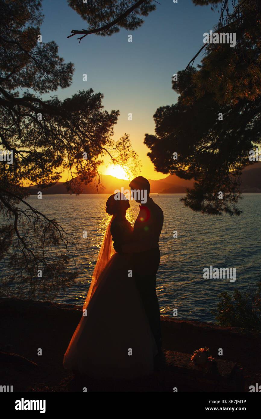 Sagome al tramonto sulla spiaggia in Montenegro Foto Stock