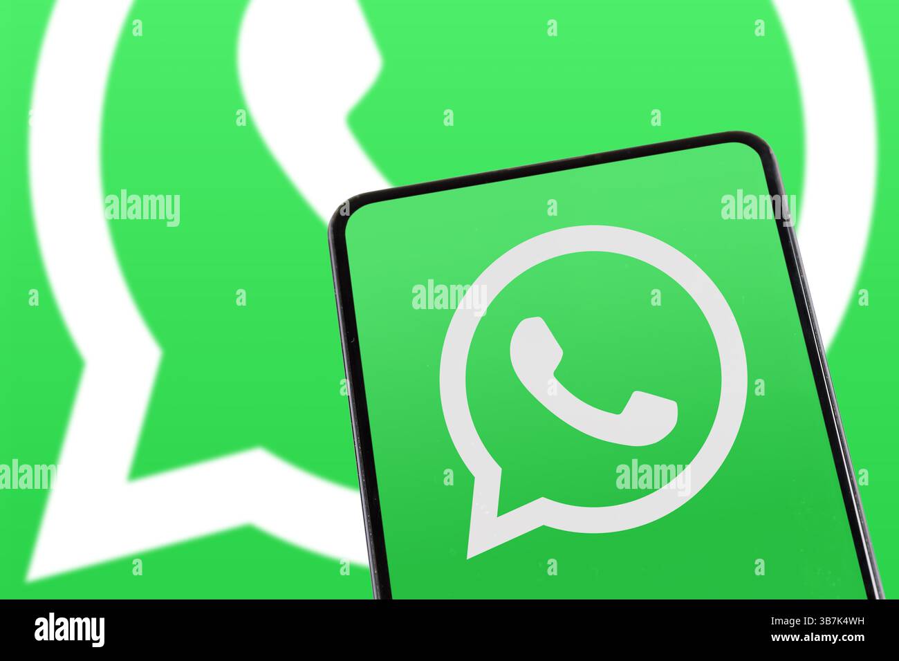 Stoccarda, Germania - 8 febbraio 2025: Applicazione di messaggistica con logo WhatsApp che invia messaggi su uno schermo di un telefono cellulare e di un computer a Stoccarda, Germania. Foto Stock