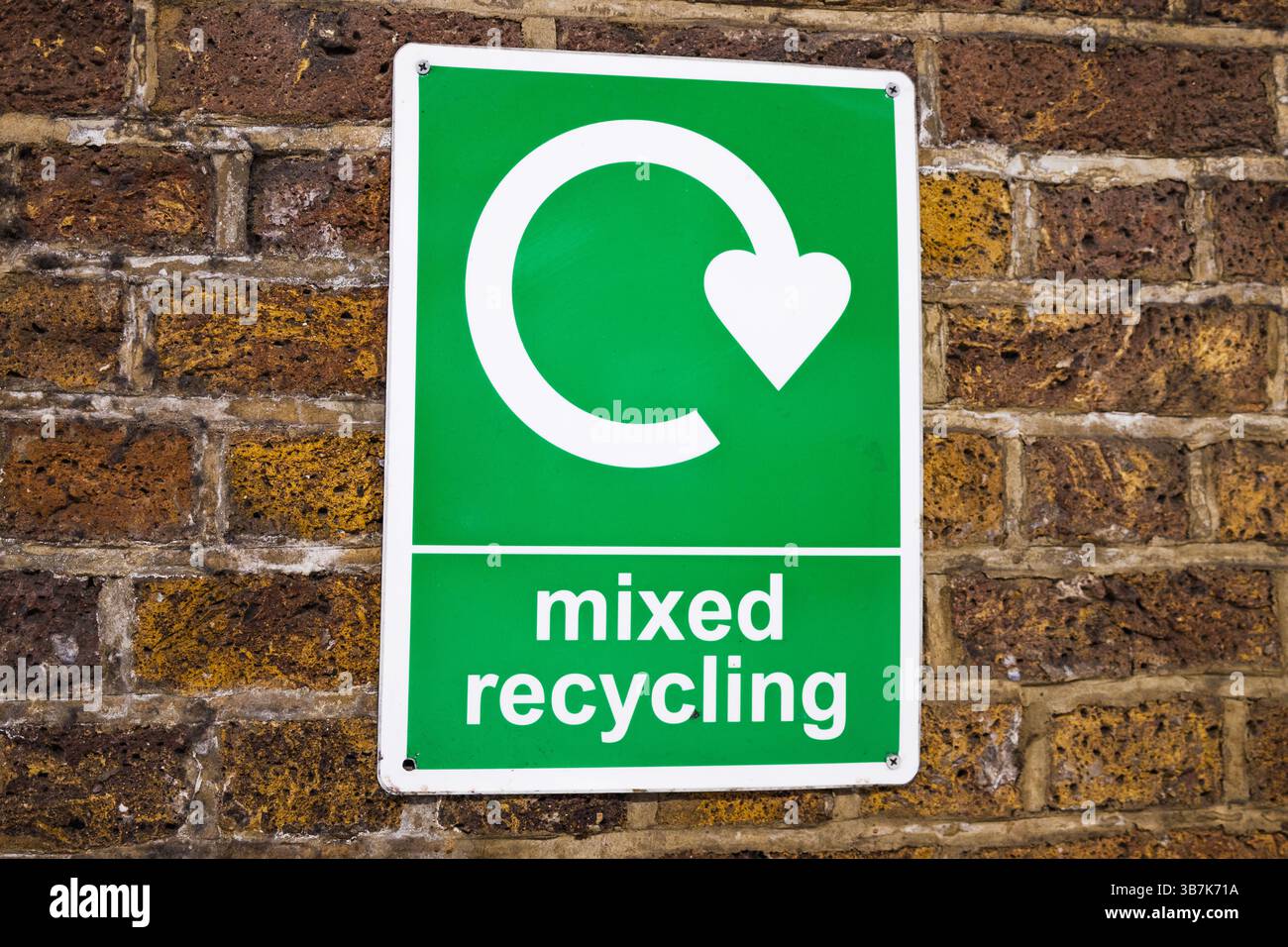 Cartello di riciclo misto sulla parete in mattoni che promuove la segregazione e il riciclaggio dei rifiuti ecologici Foto Stock