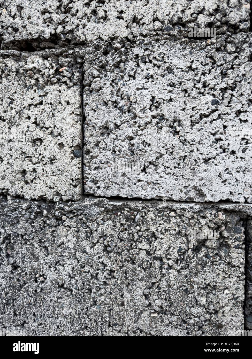 Vista macro della parete a blocchi di scorie ruvide con superficie in calcestruzzo poroso ruvida. Sfondo materiale da costruzione astratto. Niente persone. Foto Stock
