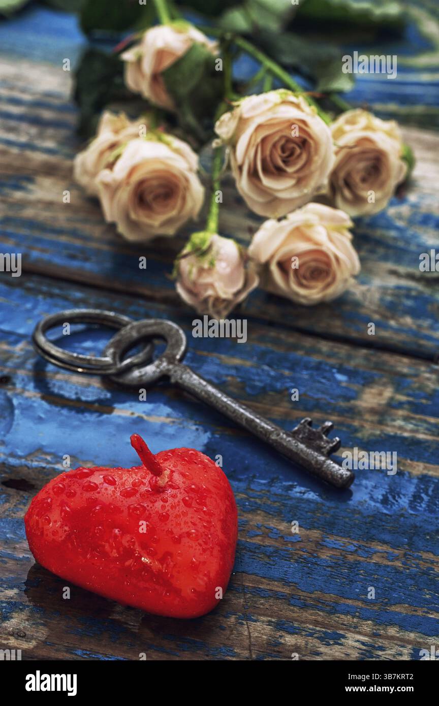 Cuore di candela simbolo d'amore, chiave e gemme di rose Foto Stock