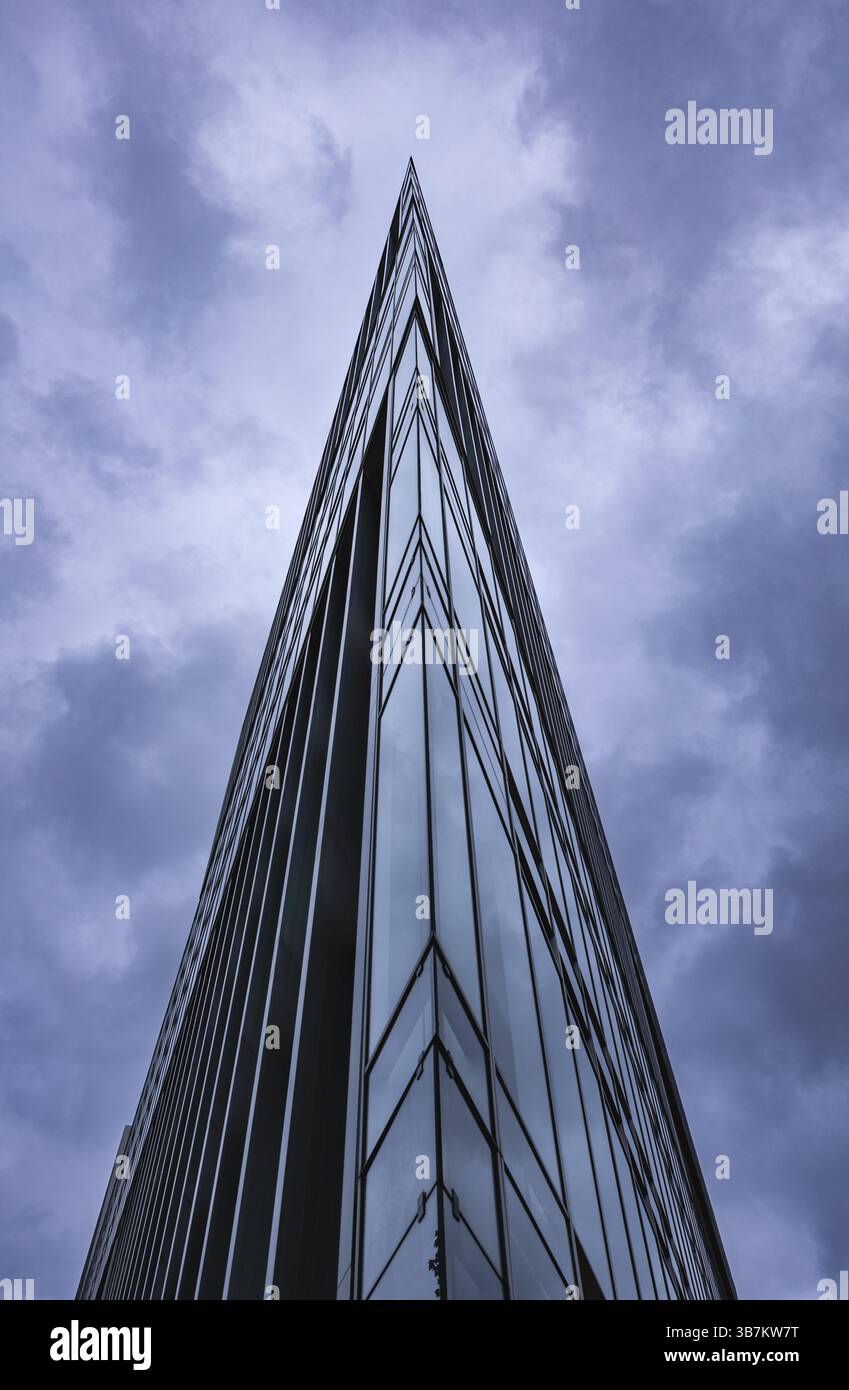 Immagine spettacolare di un grattacielo di vetro con un angolo acuto contro un cielo nuvoloso, Deichtor Centre, città libera e anseatica di Amburgo, Germania, Europa Foto Stock