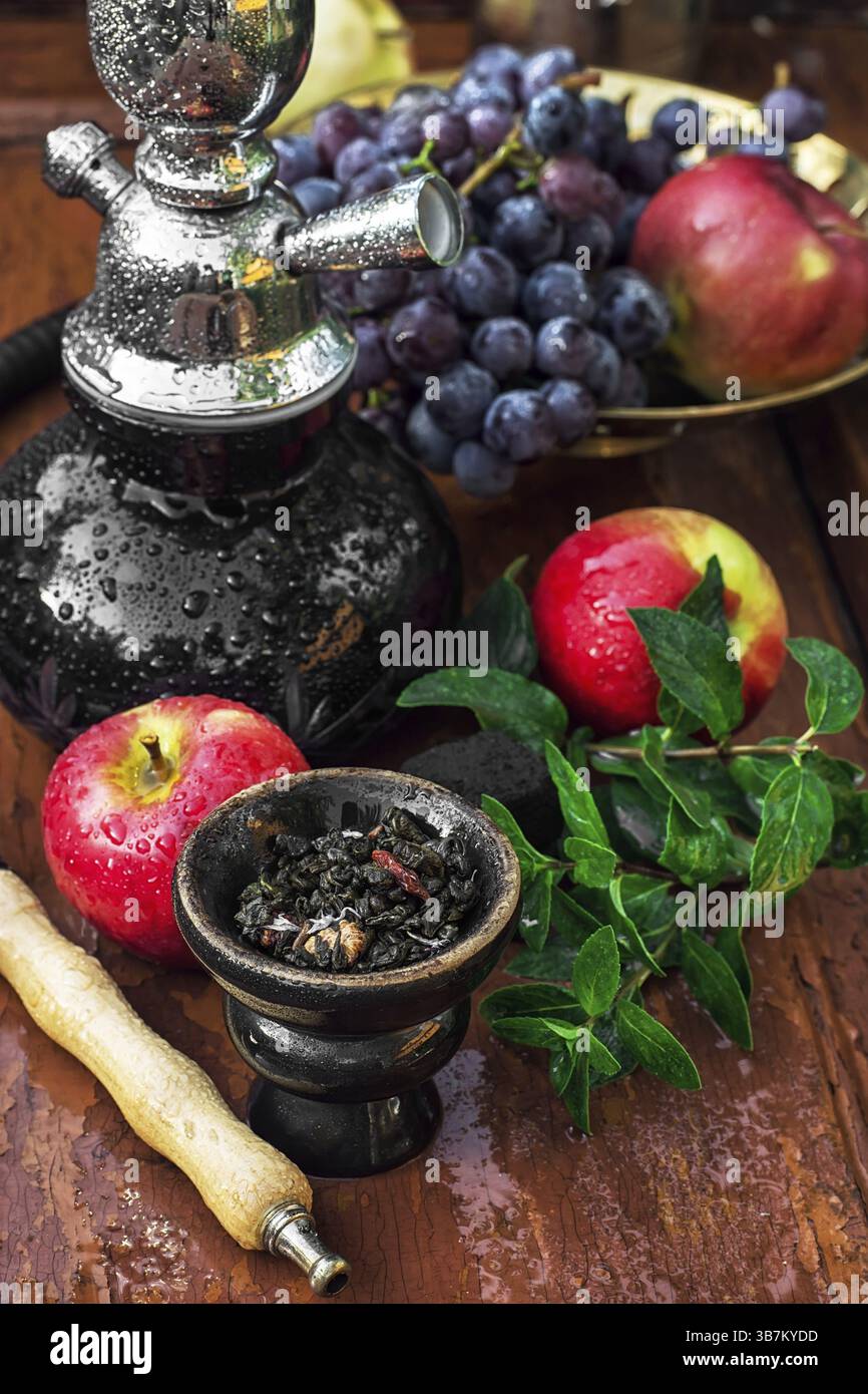 Hookah con sapore di frutta sul tavolo in legno in stile vintage Foto Stock