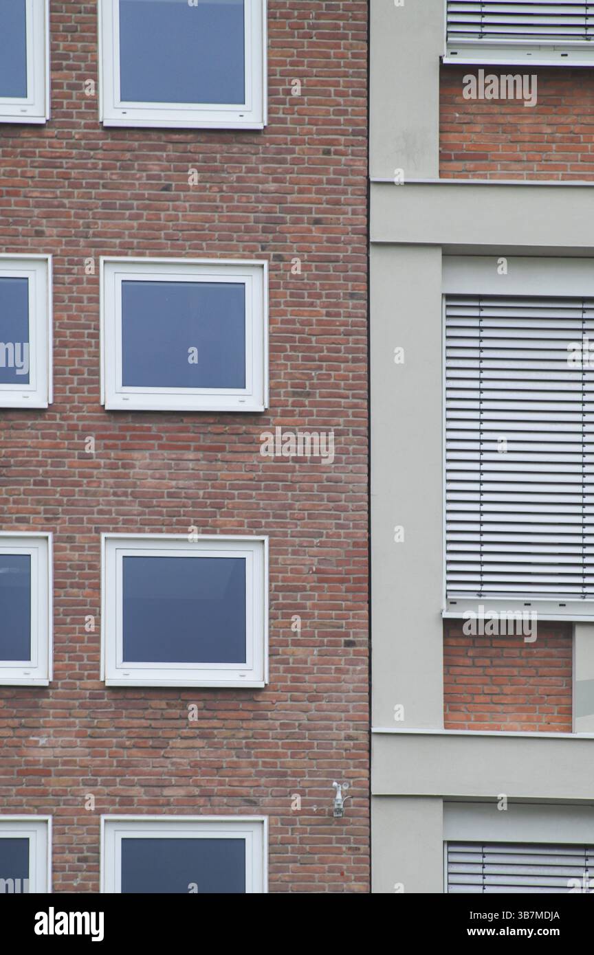 Moderna facciata di un edificio che presenta un contrasto architettonico con pareti e finestre in mattoni, mettendo in risalto il design e gli elementi di costruzione Foto Stock