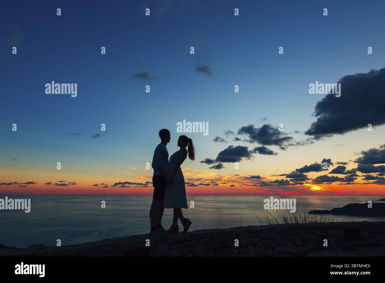 Silhouette di una coppia sposata al mare al tramonto. Matrimonio in Montenegro. Silhouette della coppia, della sposa e dello sposo Foto Stock