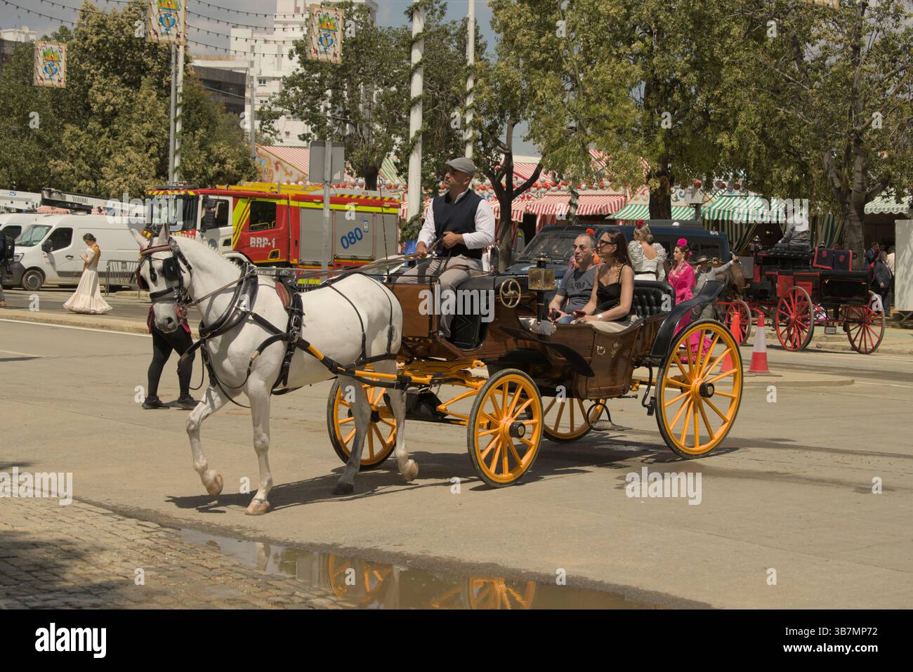Tradizionale carrozza trainata da cavalli a la Feria de Sevilla 2025, che si muove attraverso la fiera sotto la calda luce della primavera andalusa. Feria de Sevilla Foto Stock