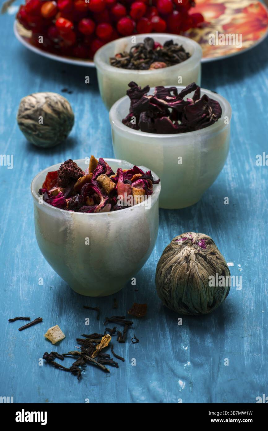 Foglie di tè essiccate per preparare il tè su un tavolo di legno Foto Stock