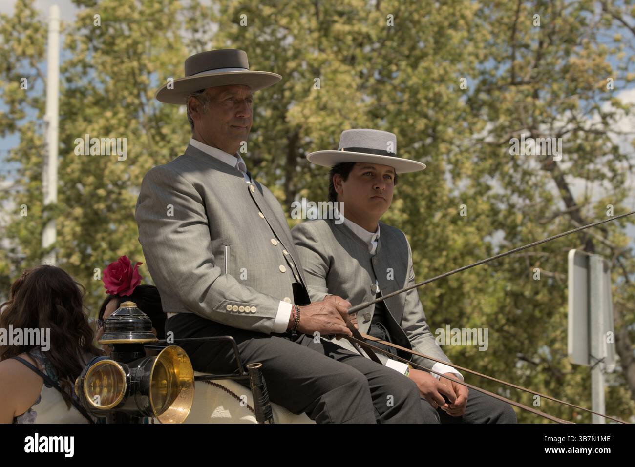 Autisti andalusi in carrozza tradizionale traje corto durante la Feria de Sevilla 2025, che rappresenta l'eleganza e l'orgoglio culturale. Feria de Sevilla Foto Stock