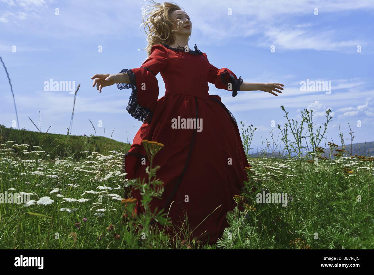 Donna bionda in abito rosso vintage che si rilassa nel prato, Stati Uniti, Nord America Foto Stock