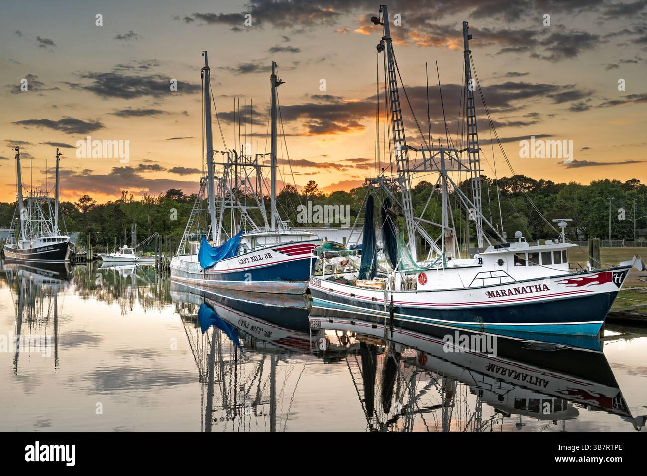 La pesca commerciale di imbarcazioni e natanti adibiti alla pesca di gamberetti legato fino al tramonto in Bayou La Batre Alabama, Stati Uniti d'America. Foto Stock
