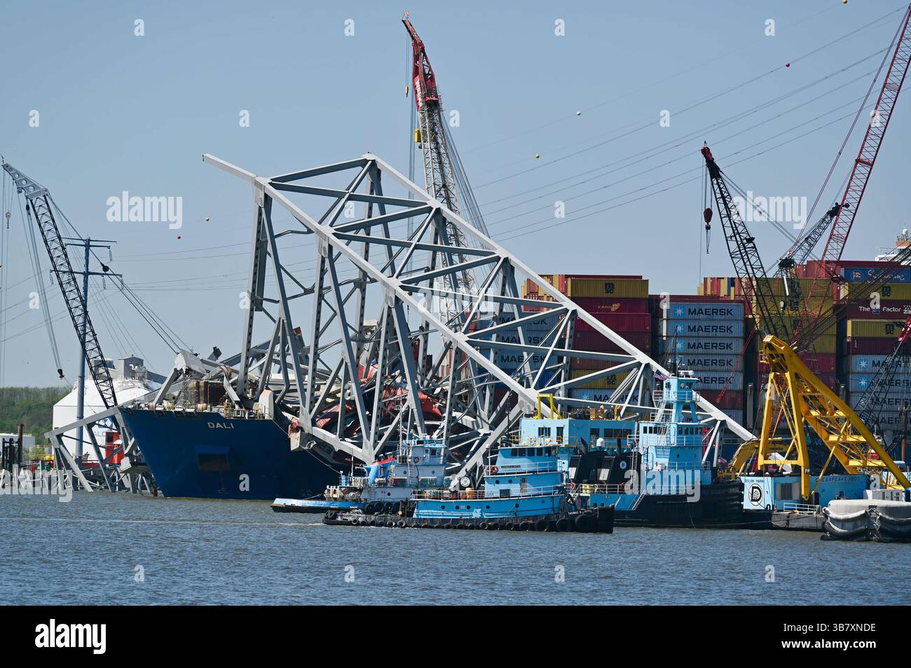 16 aprile 2024, Dundalk, MD, Stati Uniti d'America: Gru per chiatte lavoro per rimuovere capriate dal crollato Francis Scott Key Bridge intorno alla nave da carico MV Dali che blocca il canale di Fort McHenry, 16 aprile 2024, vicino a Dundalk, Maryland. Il ponte fu colpito dalla nave portacontainer di 984 piedi il 26 marzo e crollò uccidendo sei lavoratori. (Immagine di credito: © Mdgovpics/Maryland Governor/Planet Pix via ZUMA Press Wire) Foto Stock