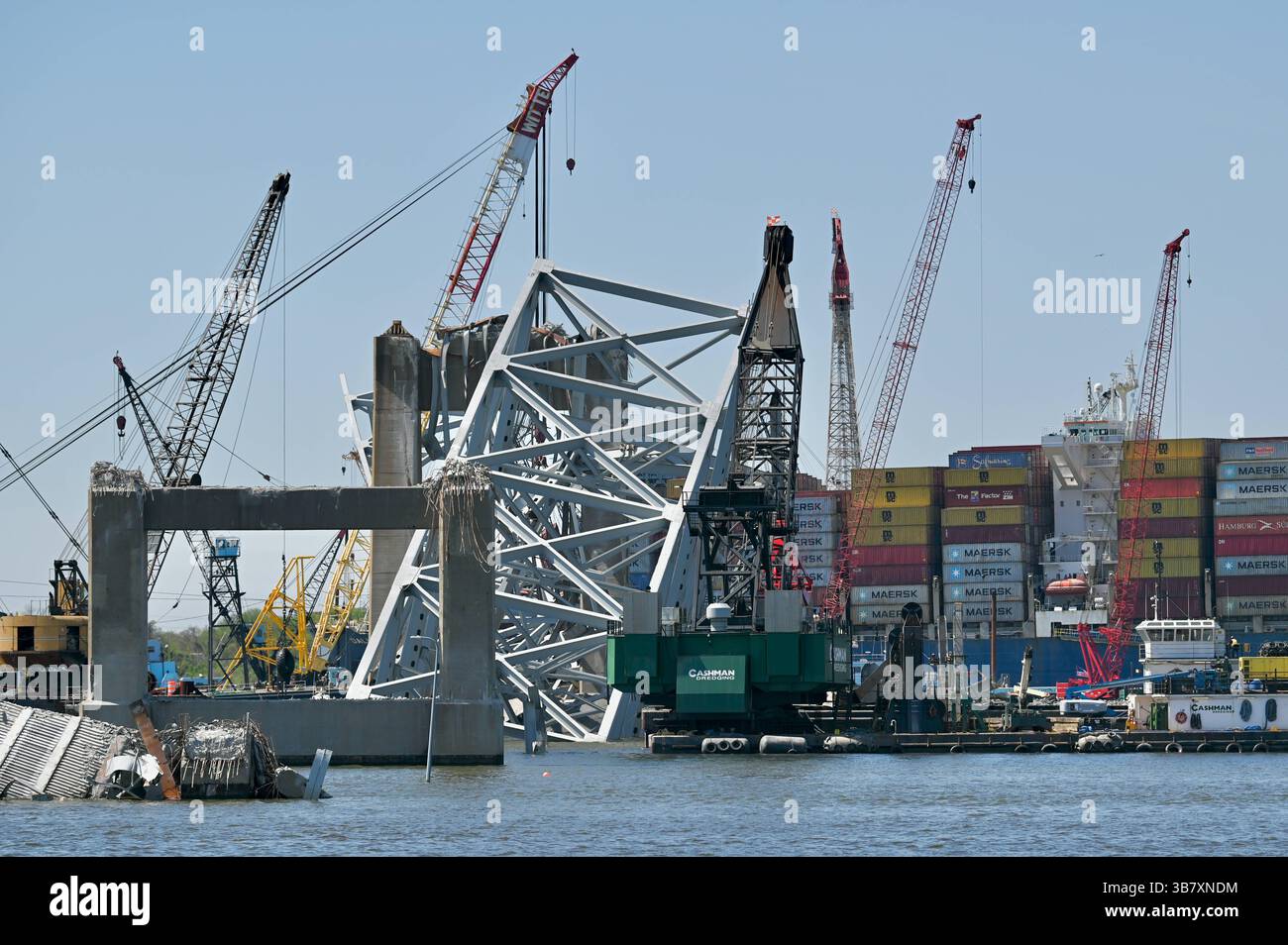 16 aprile 2024, Dundalk, MD, Stati Uniti d'America: Gru per chiatte lavoro per rimuovere capriate dal crollato Francis Scott Key Bridge intorno alla nave da carico MV Dali che blocca il canale di Fort McHenry, 16 aprile 2024, vicino a Dundalk, Maryland. Il ponte fu colpito dalla nave portacontainer di 984 piedi il 26 marzo e crollò uccidendo sei lavoratori. (Immagine di credito: © Mdgovpics/Maryland Governor/Planet Pix via ZUMA Press Wire) Foto Stock