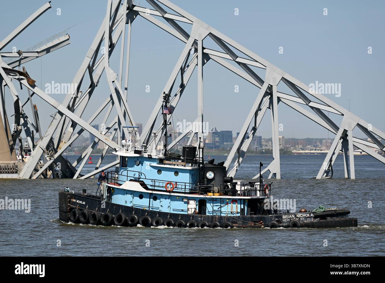 16 aprile 2024, Dundalk, MD, Stati Uniti d'America: Un rimorchiatore passa una capriata d'acciaio dal crollato Francis Scott Key Bridge bloccando il canale di Fort McHenry, 16 aprile 2024, vicino a Dundalk, Maryland. Il ponte fu colpito dalla nave portacontainer di 984 piedi il 26 marzo e crollò uccidendo sei lavoratori. (Immagine di credito: © Mdgovpics/Maryland Governor/Planet Pix via ZUMA Press Wire) Foto Stock
