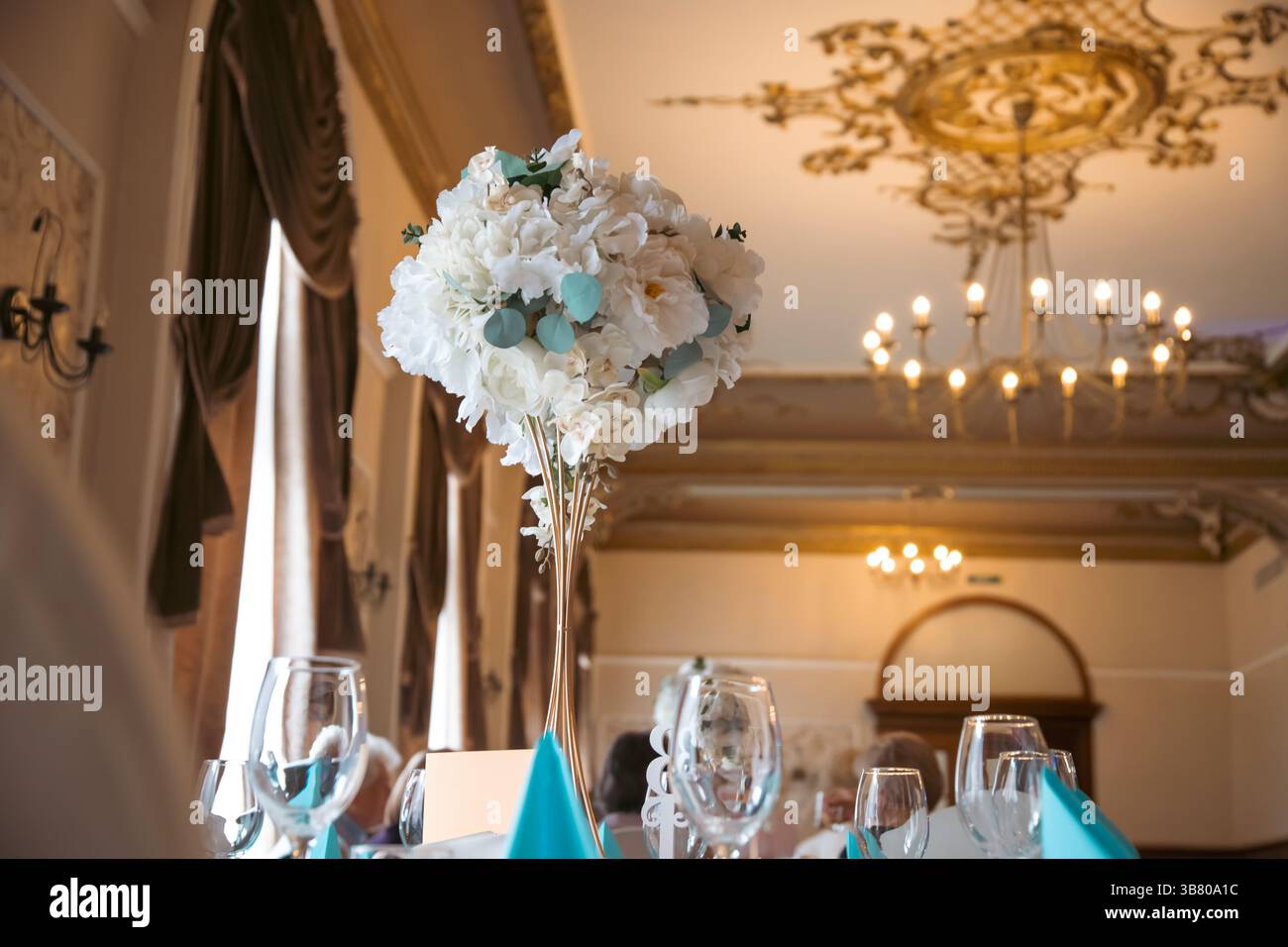 Tavolo per ricevimenti nuziali con piatti e bevande decorato con un vaso di fiori. Foto Stock