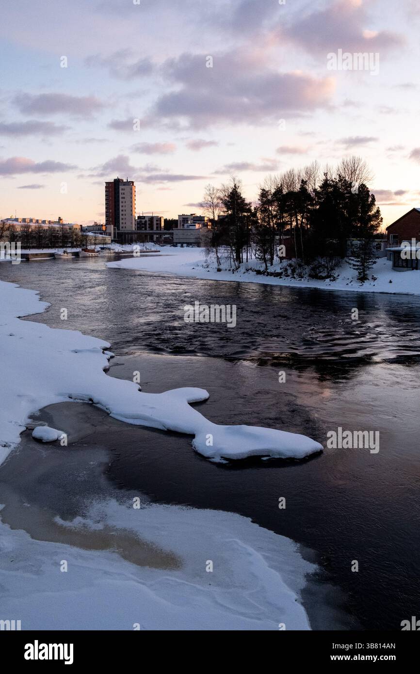 Paesaggio del fiume Pielisjoki ghiacciato al tramonto a Joensuu nella Carelia settentrionale in Finlandia il 13 marzo 2025. Joensuu è conosciuta come la silvicoltura europea Foto Stock