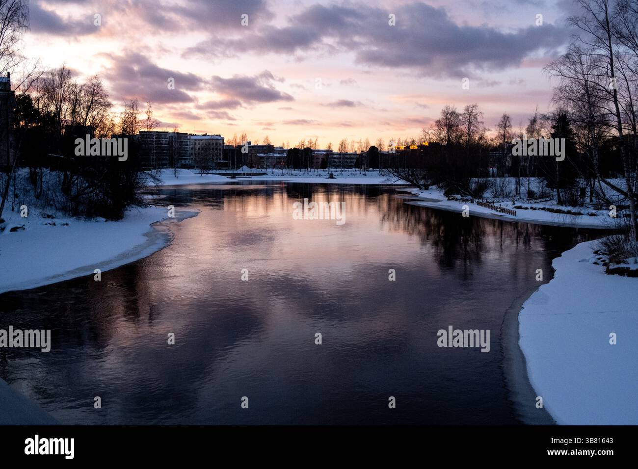 Paesaggio del fiume Pielisjoki ghiacciato al tramonto a Joensuu nella Carelia settentrionale in Finlandia il 13 marzo 2025. Joensuu è conosciuta come la silvicoltura europea Foto Stock