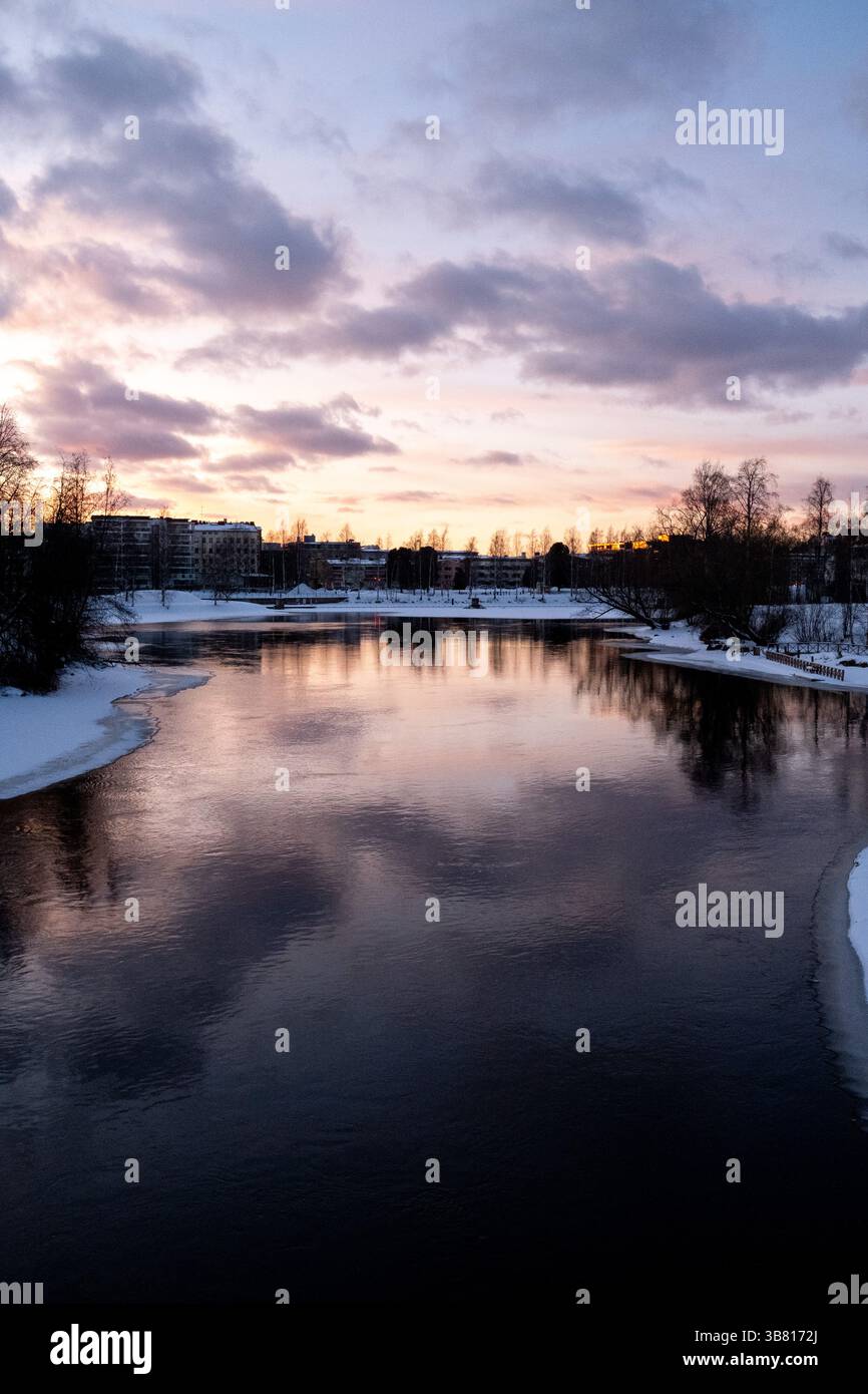 Paesaggio del fiume Pielisjoki ghiacciato al tramonto a Joensuu nella Carelia settentrionale in Finlandia il 13 marzo 2025. Joensuu è conosciuta come la silvicoltura europea Foto Stock