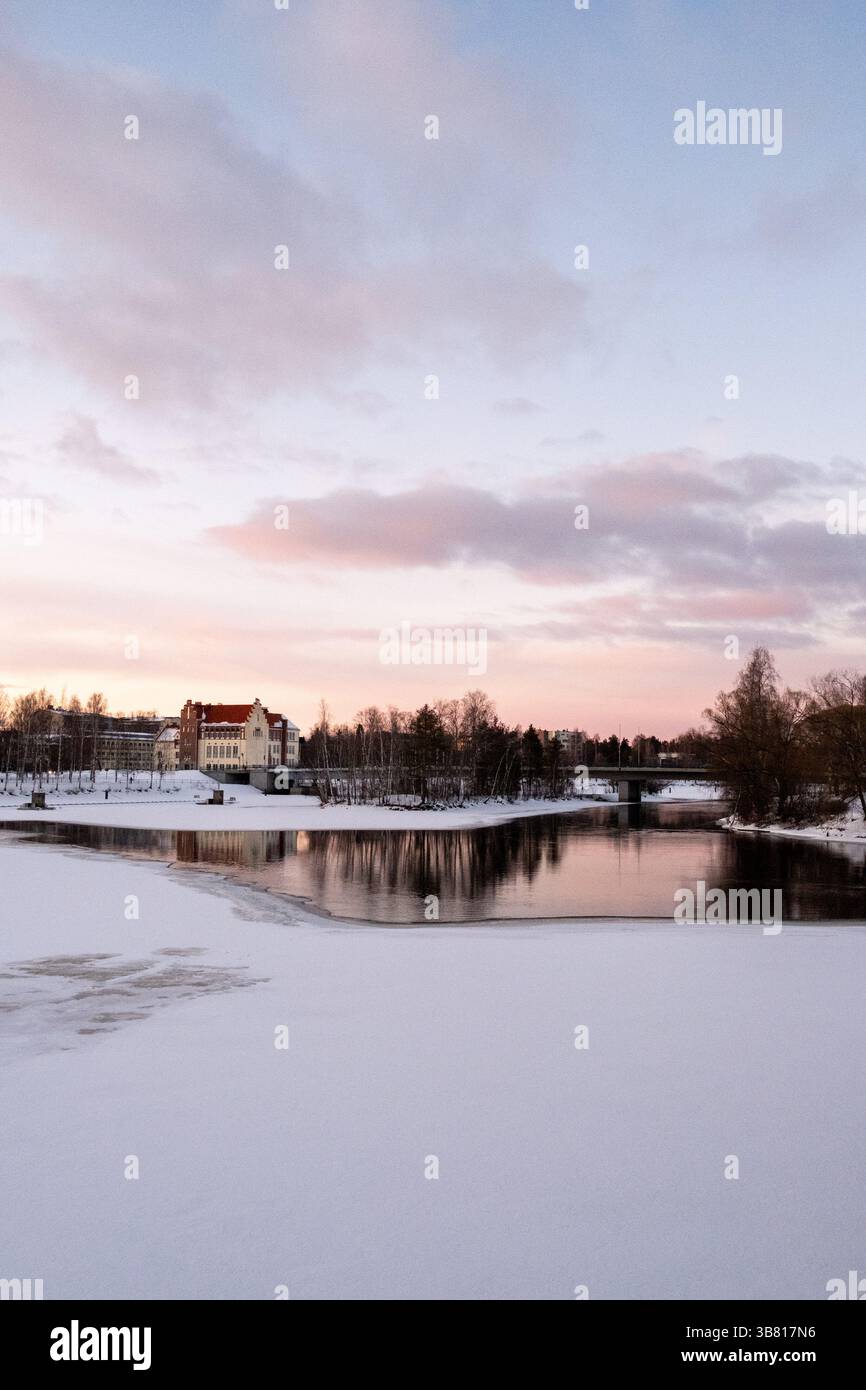 Paesaggio del fiume Pielisjoki ghiacciato al tramonto a Joensuu nella Carelia settentrionale in Finlandia il 13 marzo 2025. Joensuu è conosciuta come la silvicoltura europea Foto Stock
