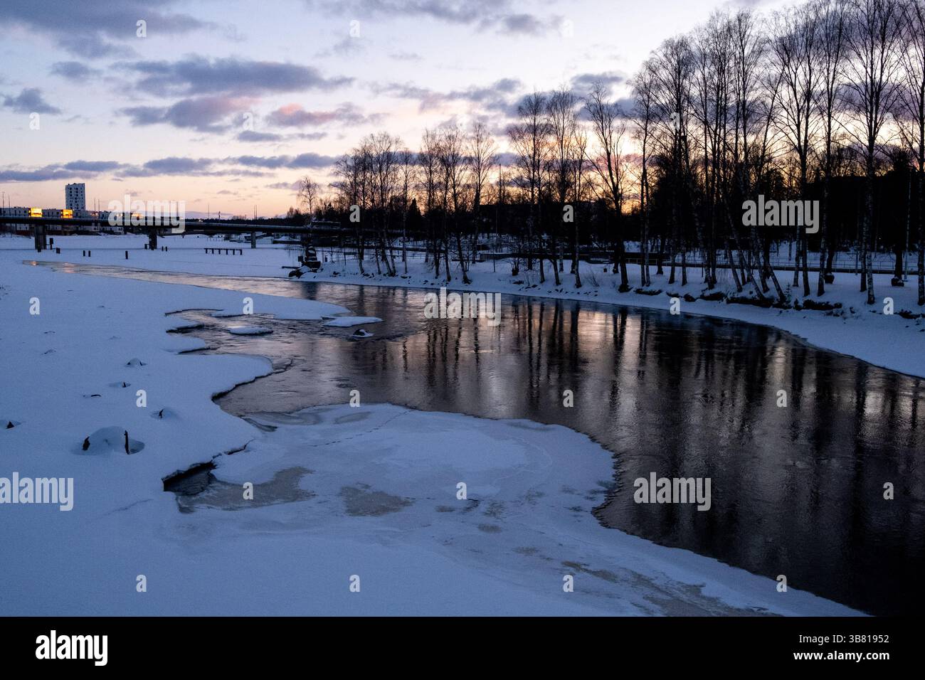 Paesaggio del fiume Pielisjoki ghiacciato al tramonto a Joensuu nella Carelia settentrionale in Finlandia il 13 marzo 2025. Joensuu è conosciuta come la silvicoltura europea Foto Stock