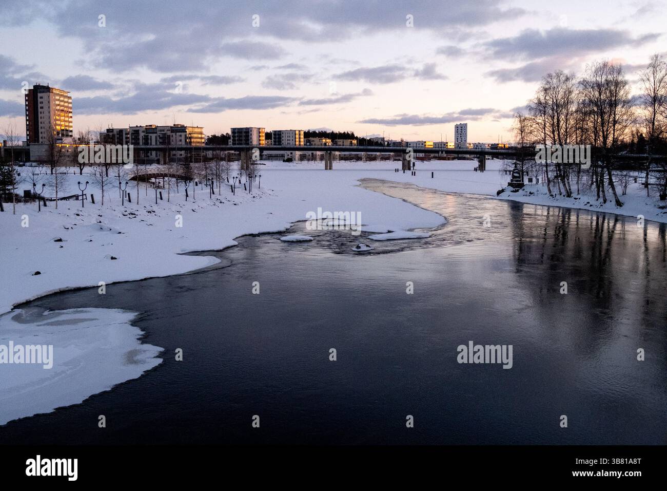 Paesaggio del fiume Pielisjoki ghiacciato al tramonto a Joensuu nella Carelia settentrionale in Finlandia il 13 marzo 2025. Joensuu è conosciuta come la silvicoltura europea Foto Stock