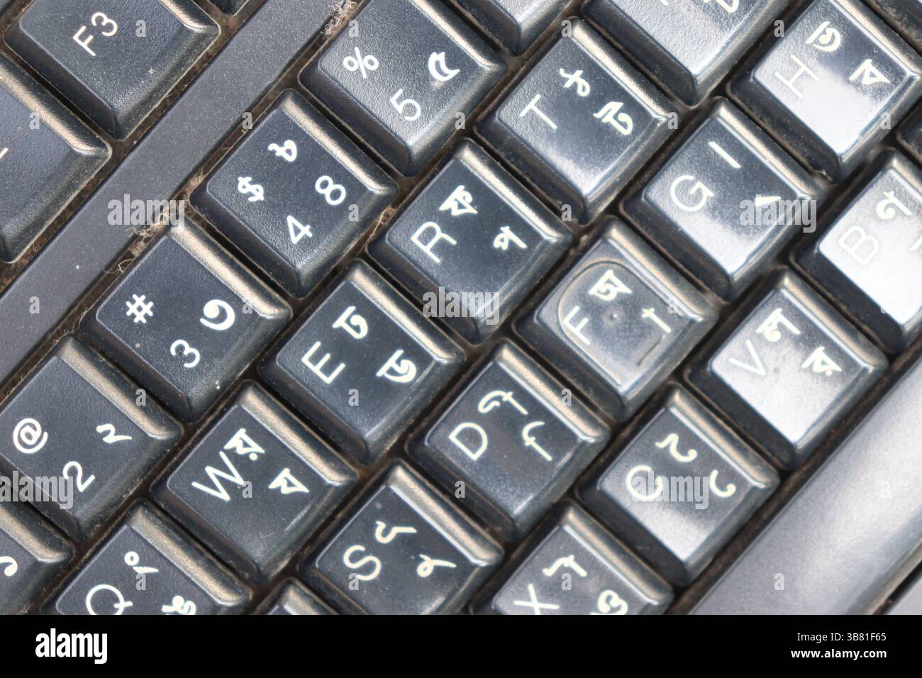 Foto ravvicinata dettagliata che mostra i tasti di una tastiera bilingue, con alfabeti inglese e bengalese, per una visione chiara del loro layout Foto Stock