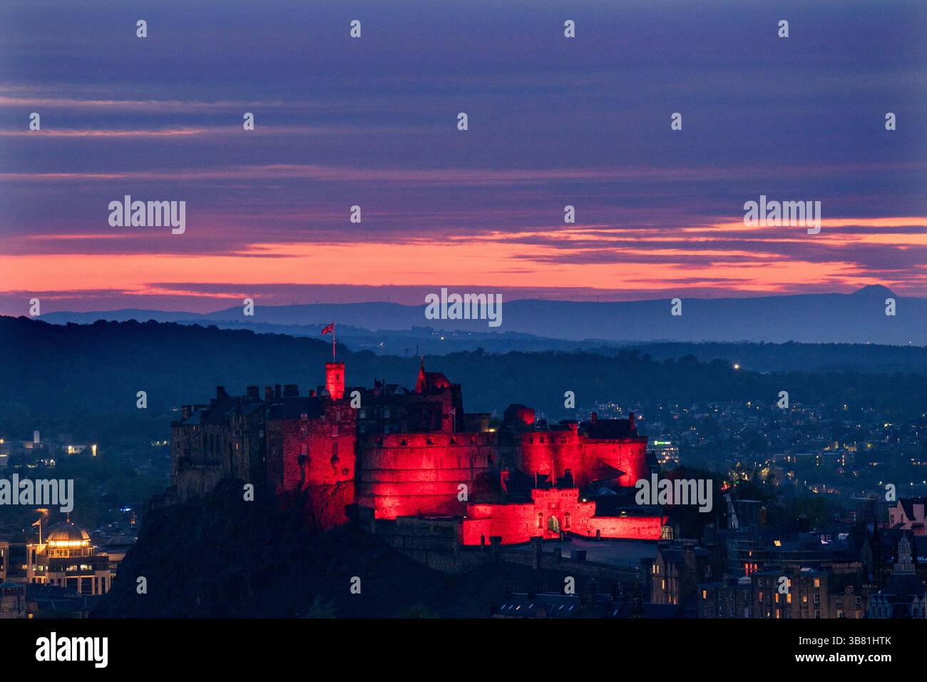 Il Castello di Edimburgo è illuminato di rosso, dato che i monumenti storici di tutto il Regno Unito sono illuminati per il 80° anniversario del VE Day. Data foto: Martedì 6 maggio 2025. Foto Stock